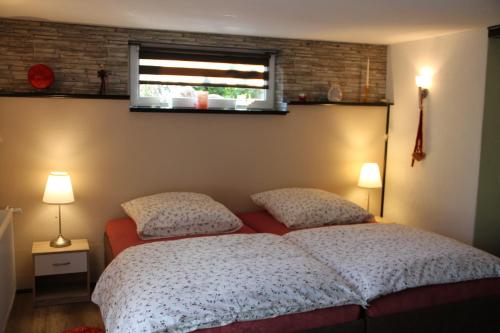 a bedroom with a bed with two pillows and a window at Apartment am Bieleboh in Beiersdorf