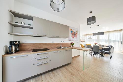 a kitchen with white cabinets and a dining room at Ribarska Koliba Resort in Pula