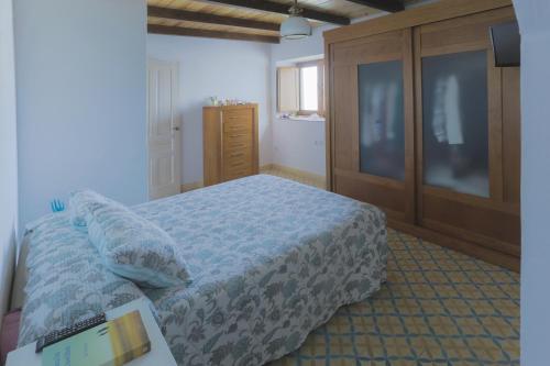 um quarto com uma cama e uma cómoda em madeira em Casa de Campo La Estancia em Tarifa