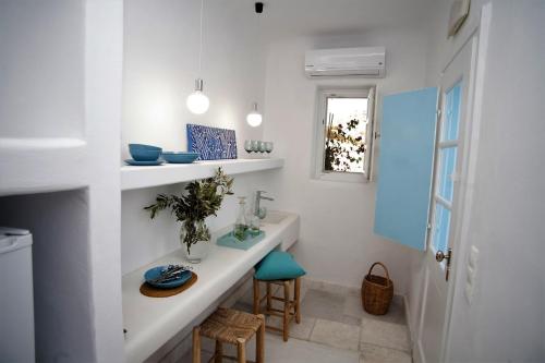 a white room with a table and a window at Mykonos Moussa in Agios Ioannis Mykonos