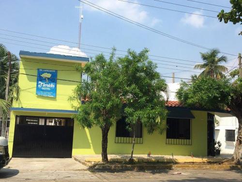 a yellow and green building with a tree in front of it at Hotel Florida in Villahermosa