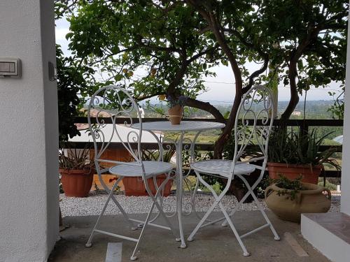 a table and chairs on a patio with a tree at Su Sole in Posada