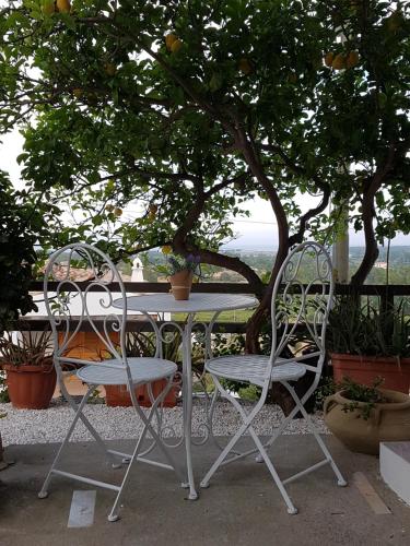 a table and two chairs sitting next to a tree at Su Sole in Posada