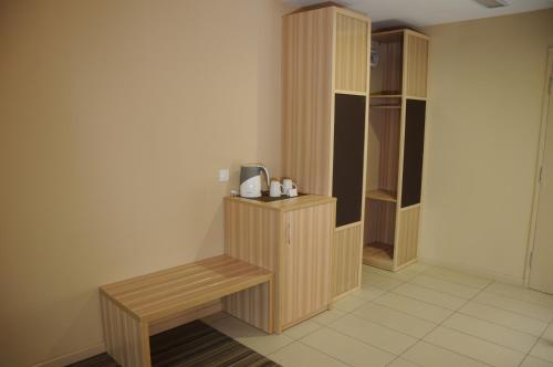 a room with a wooden bench and a closet at Zara's Boutique Hotel @ Harbour City in Kota Kinabalu