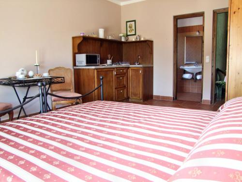a bedroom with a bed and a kitchen with a sink at Villa Toscana in Hajdúszoboszló