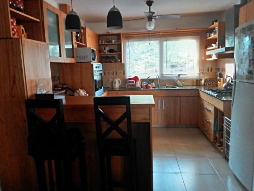 una cocina con encimera y 2 sillas. en La casa de Silvia en Puerto Madryn