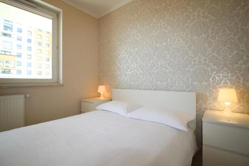 グダニスクにあるSea Apartmentのベッドルーム(白いベッド1台、窓付)