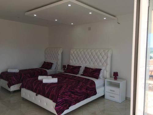 a bedroom with two beds and a mirror at Queen Kodre Apartments in Ulcinj