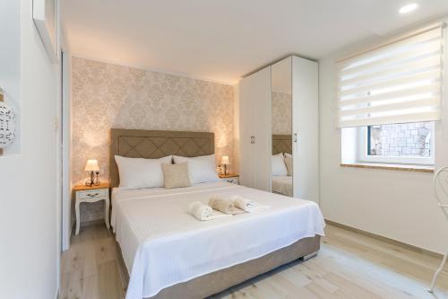 a bedroom with a white bed with two towels on it at Split Center Apartments in Split