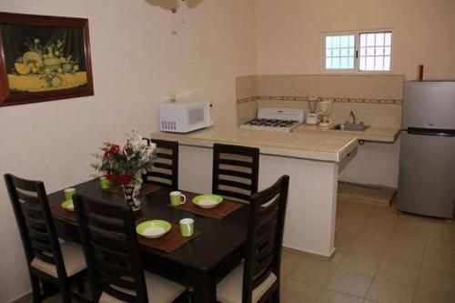 a kitchen with a table and chairs and a kitchen with a refrigerator at Residencial Gran Santa Fe Cancun in Cancún