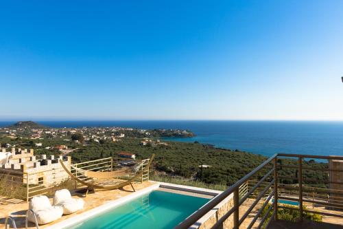 a villa with a swimming pool and a view of the ocean at Tseralia Houses in Stoupa