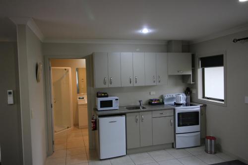 a small kitchen with white appliances and a window at 200 on Lake View in Karapiro