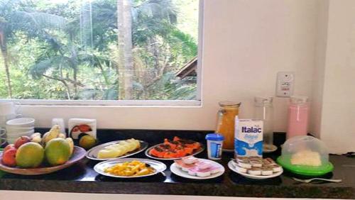 a counter with plates of food on a counter top at Pousada Sol da Trindade in Trindade