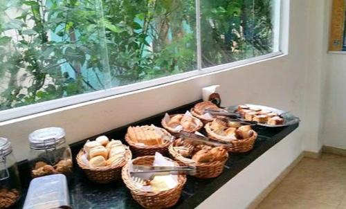 a counter with baskets of pastries and a window at Pousada Sol da Trindade in Trindade