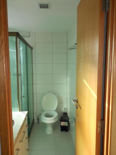 a bathroom with a white toilet and a sink at Flat Beira Mar in Recife