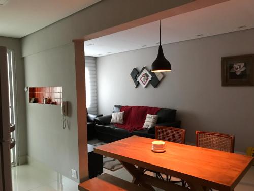 a living room with a table and a couch at Apartamento Zapata Guarujá in Guarujá