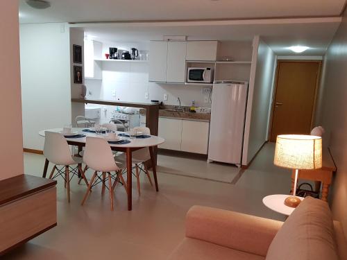 uma cozinha e sala de estar com mesa e cadeiras em Maceio Facilities Apartamento Temporada em Maceió