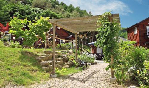 a garden with a pavilion in front of a house at Sisilli Pension in Pyeongchang 