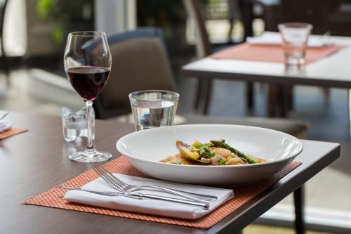 a table with a bowl of food and a glass of wine at Novotel Sydney Olympic Park in Sydney