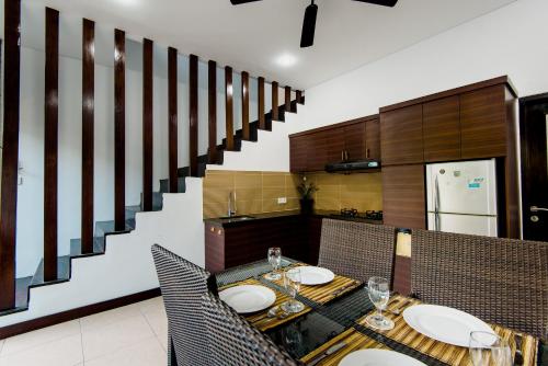 a dining room with a table and chairs and a staircase at Villa Raka Managed by Manara in Legian