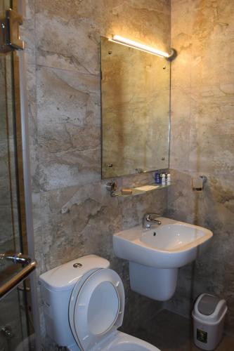 a bathroom with a white toilet and a sink at Cirute' Talwatte, Kandy in Kandy
