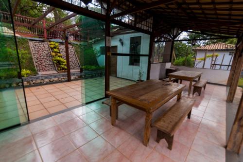 an outdoor patio with a wooden table and benches at Pousada do Canto in Rio Acima
