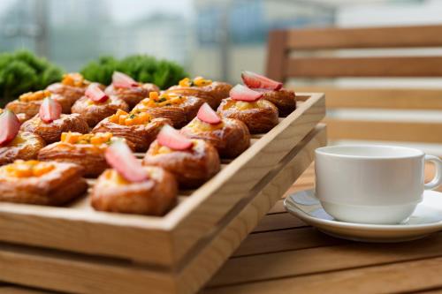 a tray of pastries on a table with a cup of coffee at Kempinski Hotel Fuzhou in Fuzhou