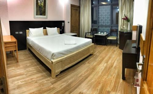 a bedroom with a large bed and a desk at Nice Hotel in Hanoi