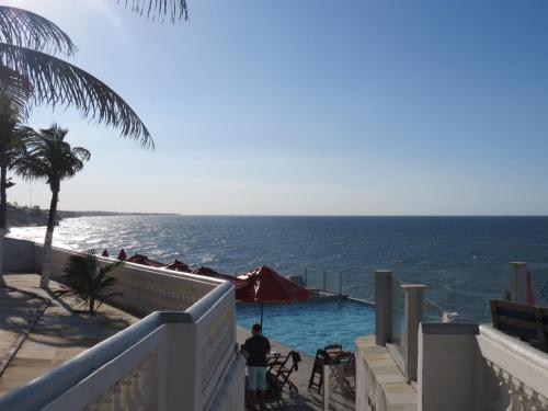 a swimming pool with the ocean in the background at La Suite Praia Hotel in Caucaia