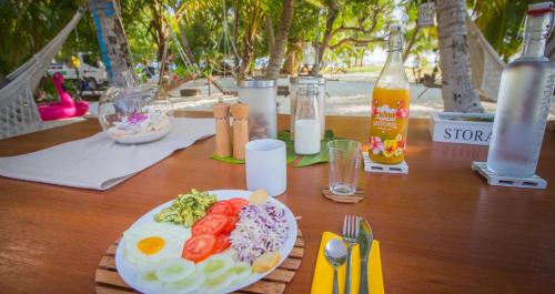 a table with a plate of food and bottles of milk at Kahanbu Ocean View in Thulusdhoo