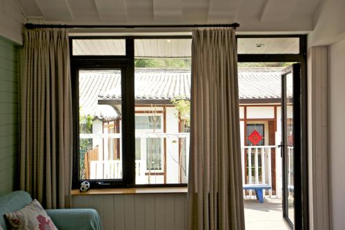 a window with curtains in a room with a patio at The Great Wall Box House - Beijing in Miyun