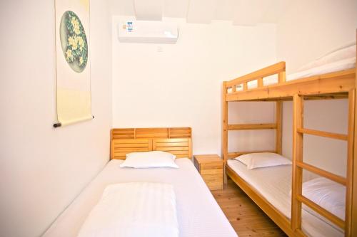 a bedroom with two bunk beds and a mirror at The Great Wall Box House - Beijing in Miyun