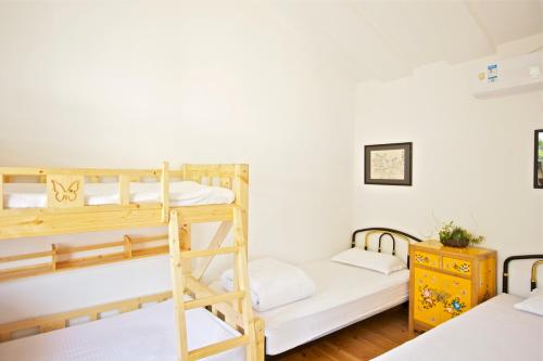 a bedroom with two bunk beds and a desk at The Great Wall Box House - Beijing in Miyun