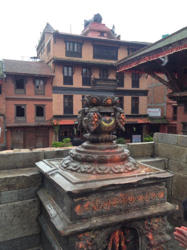 a statue in front of a large building at Shiva Guest House in Bhaktapur