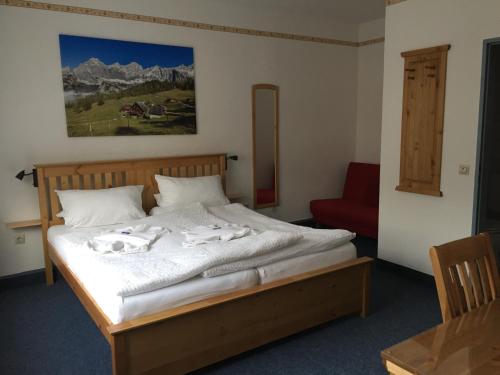 - une chambre avec un grand lit et une chaise rouge dans l'établissement Hotel Stangl, à Hamm