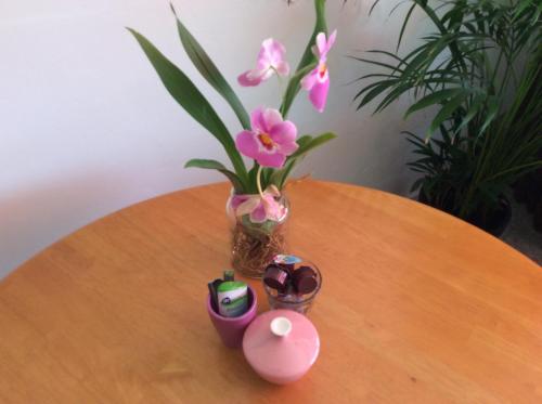 a vase with pink flowers sitting on top of a table at Imagine My B&B in Rotterdam