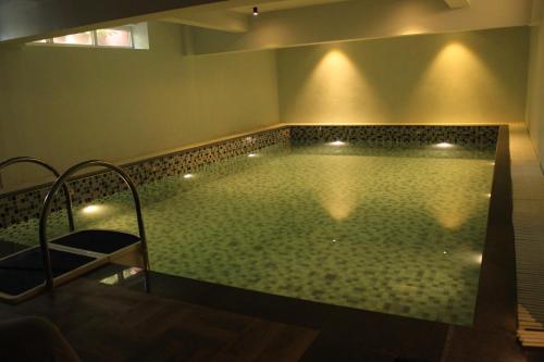 a swimming pool with lights in a room at Hotel Mount Regency in Mount Ābu