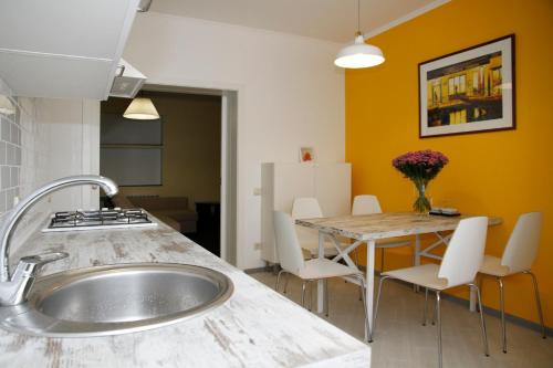 cocina con fregadero y mesa con sillas en Guest House Venezia, en Anapa