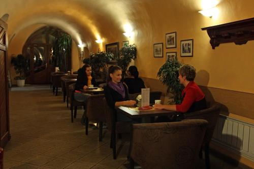 een groep mensen die aan tafel zitten in een restaurant bij Hotel Čierny Orol in Rožňava