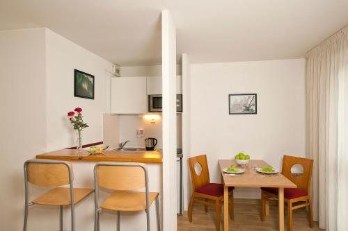 a kitchen and dining room with a table and chairs at Séjours & Affaires Angers Atrium in Angers