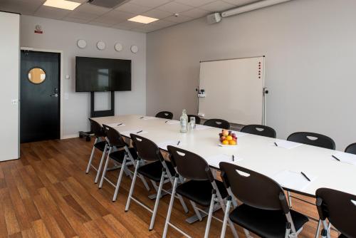 a conference room with a large table and chairs at Strandpiren Hotell in Hudiksvall