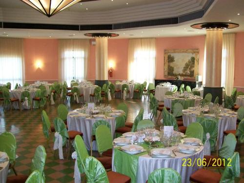 a banquet hall with white tables and green chairs at Hotel Ambasciatori in Calitri