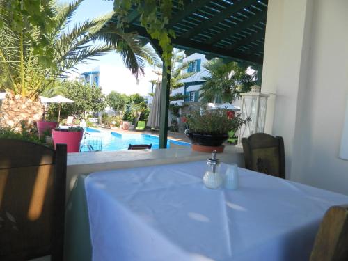 a table with a white table cloth on a table with a pool at Ioanna Apartments in Agios Prokopios