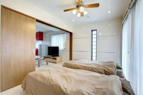 a bedroom with two beds and a ceiling fan at Terrace Resort Ginowan in Ginowan