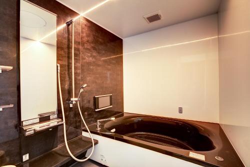 宜野灣的住宿－宜野灣露台度假公寓，设有带浴缸和淋浴的浴室。