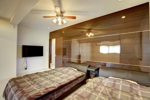 宜野灣的住宿－宜野灣露台度假公寓，一间卧室配有两张床和吊扇
