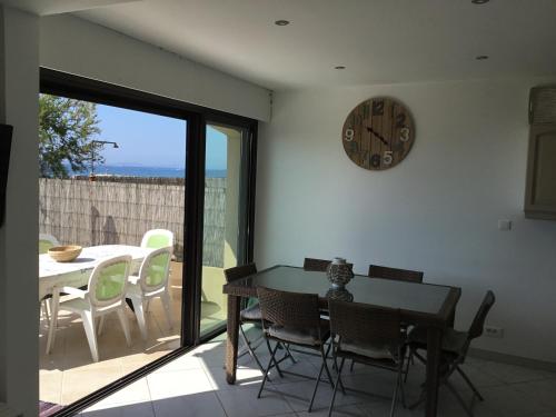 une salle à manger avec une table et une horloge au mur dans l'établissement Résidence des Sables d'Or, à La Croix-Valmer