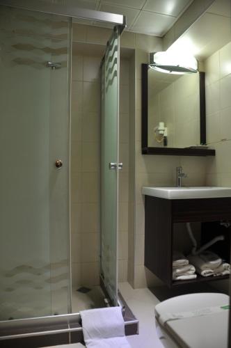 a bathroom with a glass shower and a sink at İzmir Otel Kabaçam in İzmir
