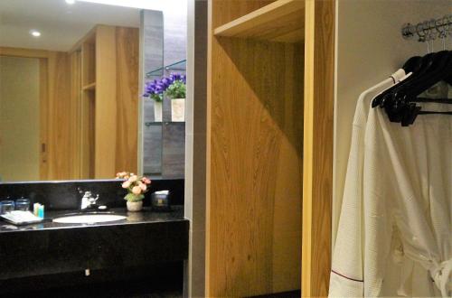 a bathroom with a sink and a mirror at Greens Hotel & Suites in Bintulu