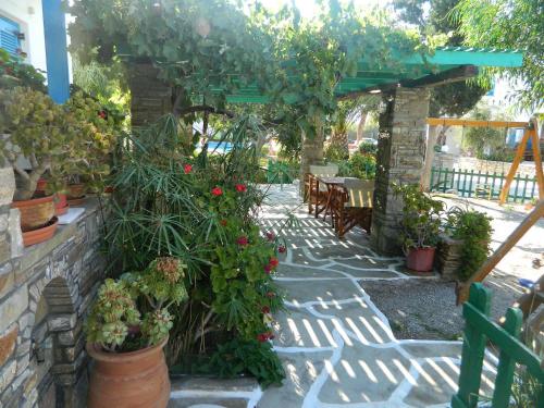 a patio with potted plants and tables and chairs at Ioanna Apartments in Agios Prokopios